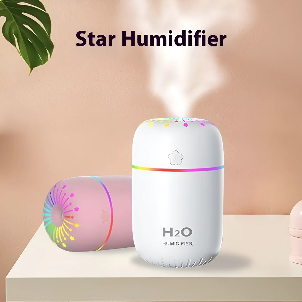 Small white cube-shaped USB humidifier with water tank on a wooden desk.