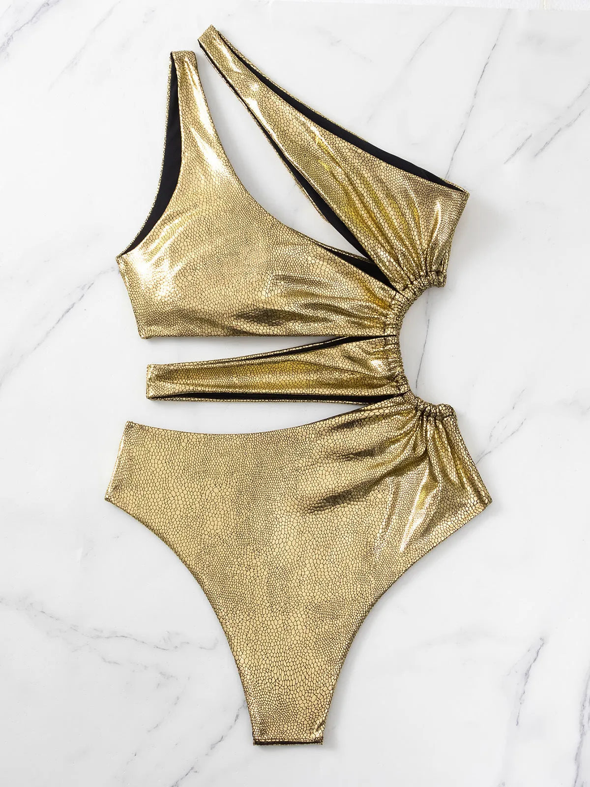 Women's gold backless one-piece swimsuit made from Spandex, shown on a mannequin.