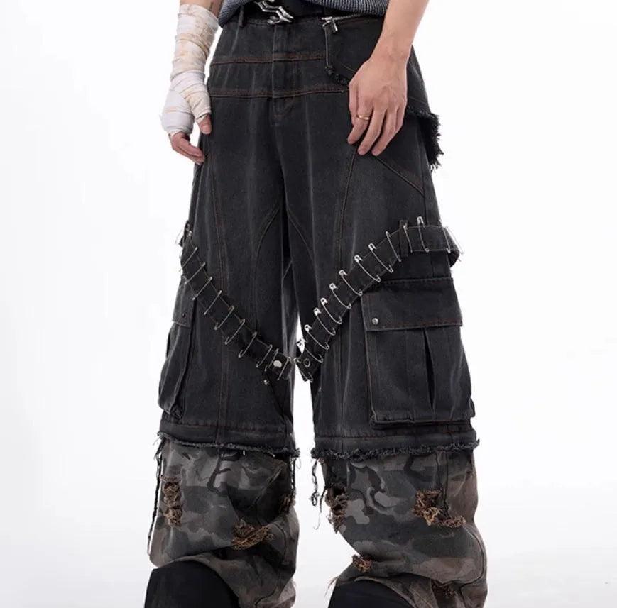 Men's grey cotton jeans with camouflage pattern splicing and decorative pin and ribbon details on the legs.