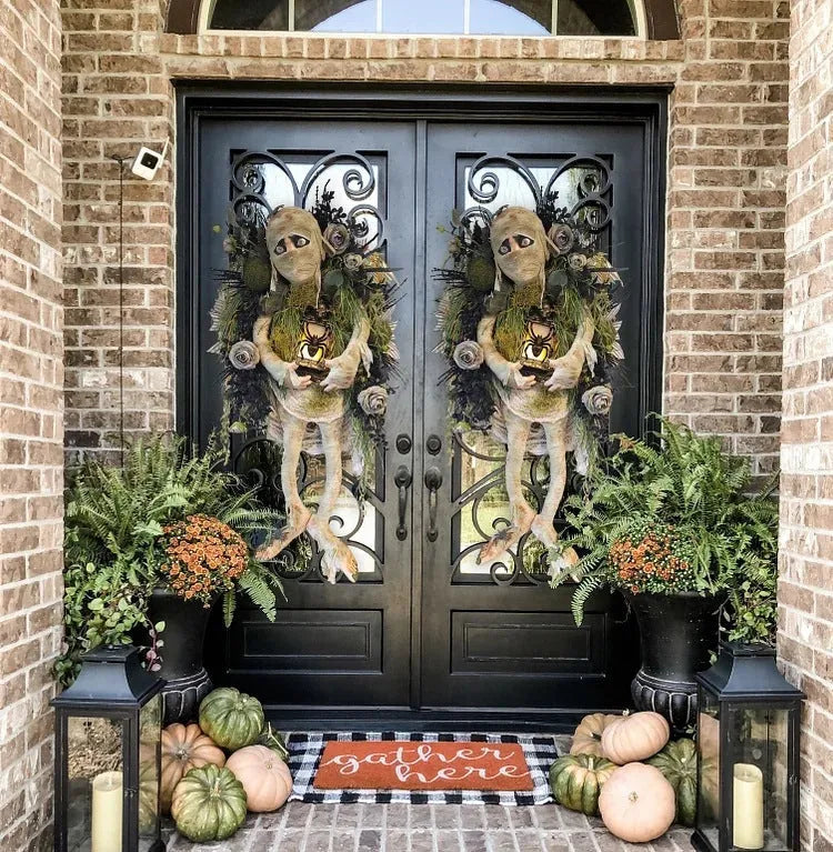 Three-dimensional mummy Halloween wreath with skeleton hands on a wooden door