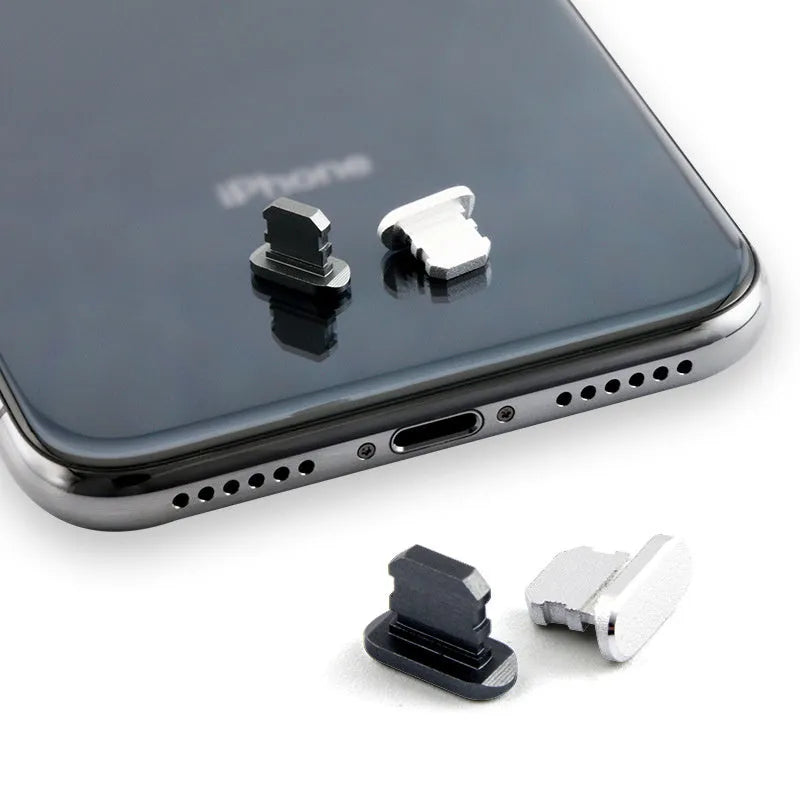 Aluminium alloy iPhone charging port dust plug in rose gold colour next to an iPhone.
