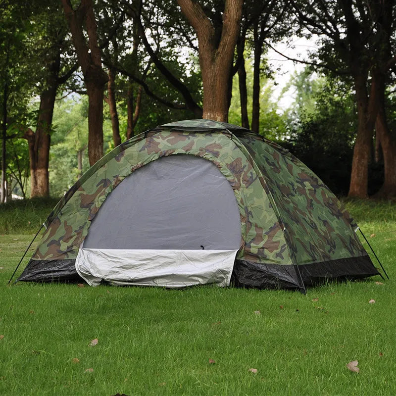 Green camouflage two-person dome tent with mesh panels and guylines pitched outdoors.
