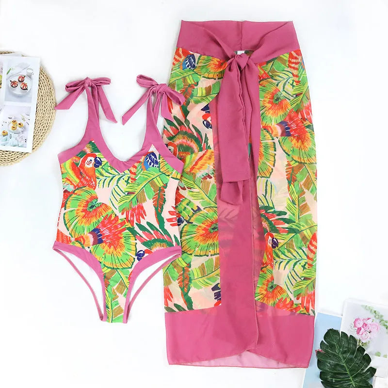 Retro pink floral print women's one-piece swimsuit with V-neck and attached thin skirt.