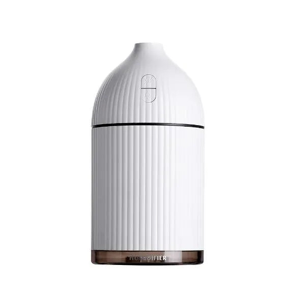 White ultrasonic aromatherapy diffuser and humidifier with LED light on a wooden surface