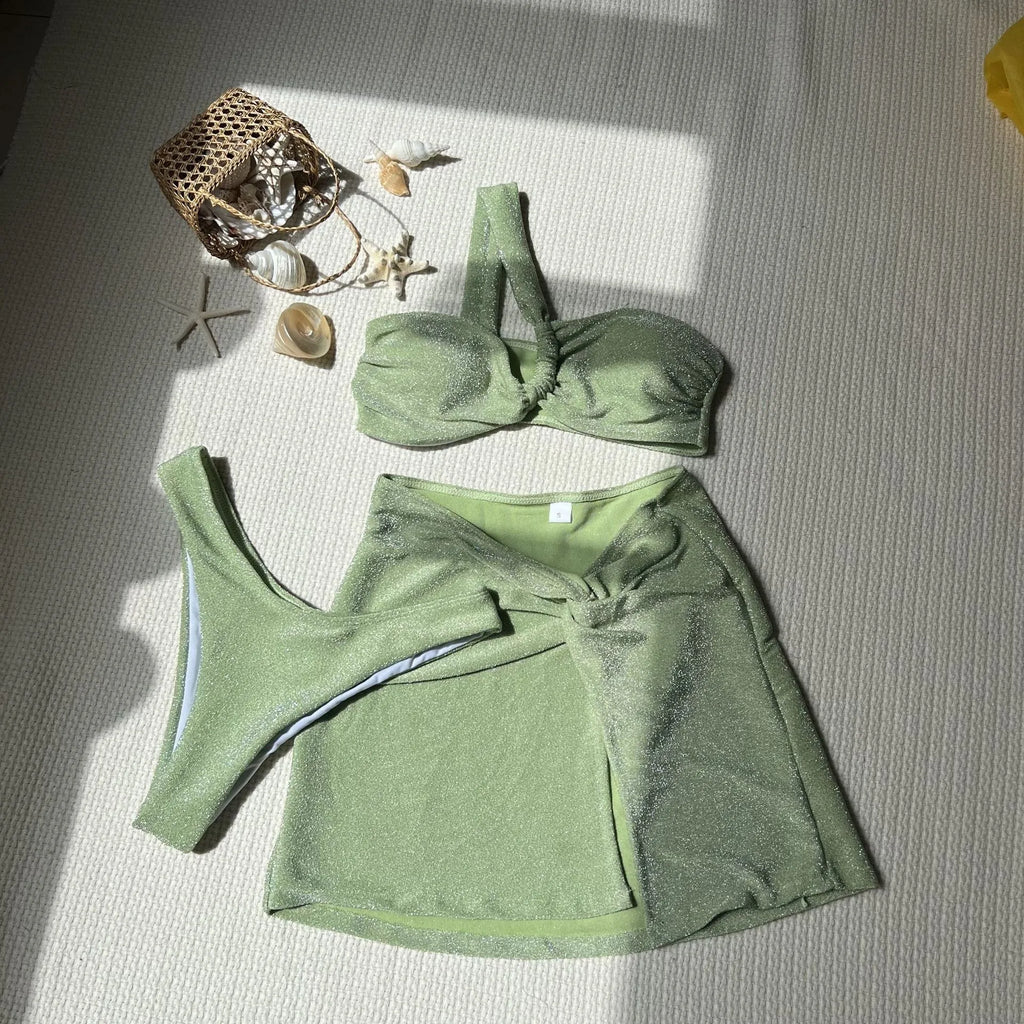 Light green one-shoulder tube top three-piece swimsuit set with high-waisted bottom and skirt.