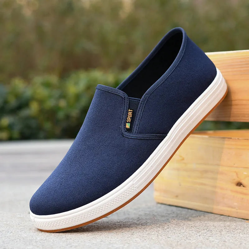 Men's low-top canvas slip-on shoes in blue colour showing round-toe design and composite soles