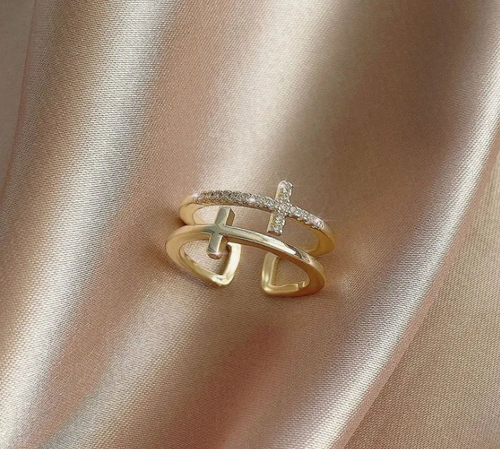 Adjustable double cross geometric ring in copper with cubic zirconia stones, shown in a gold colour finish.