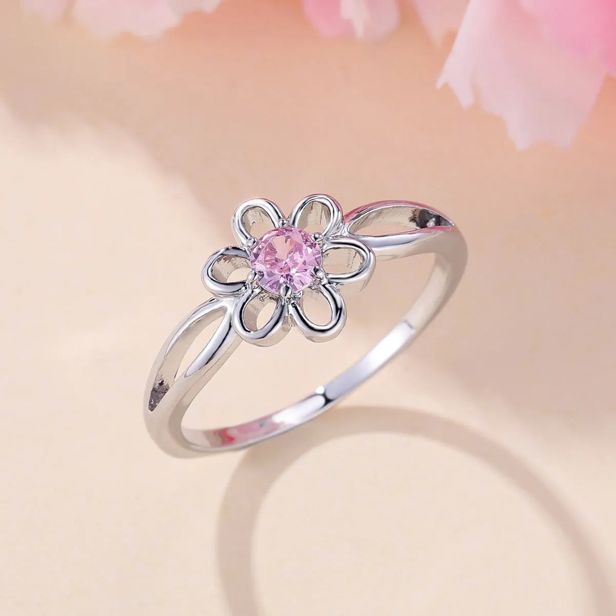 Lady's copper flower hollowed ring with electroplated finish in white gold powder colour on white background