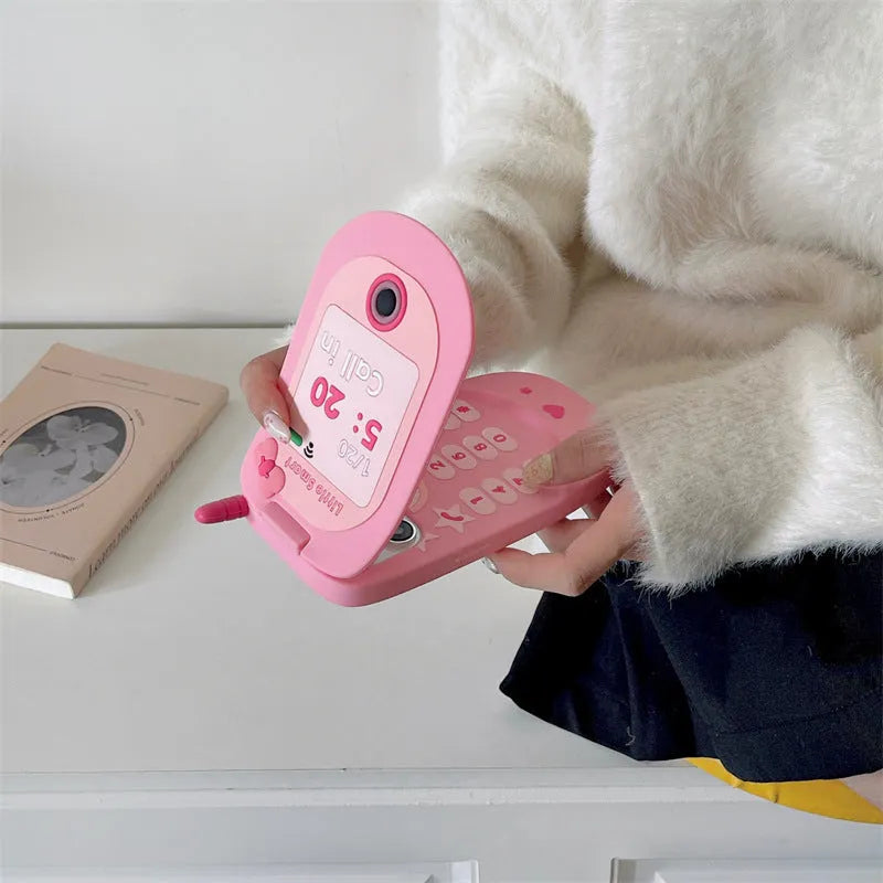 Light pink silicone flip phone shaped mirror case for iPhone on a white background.