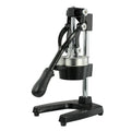 Tall black manual citrus juicer with cast iron base and stainless steel cone on a kitchen counter.