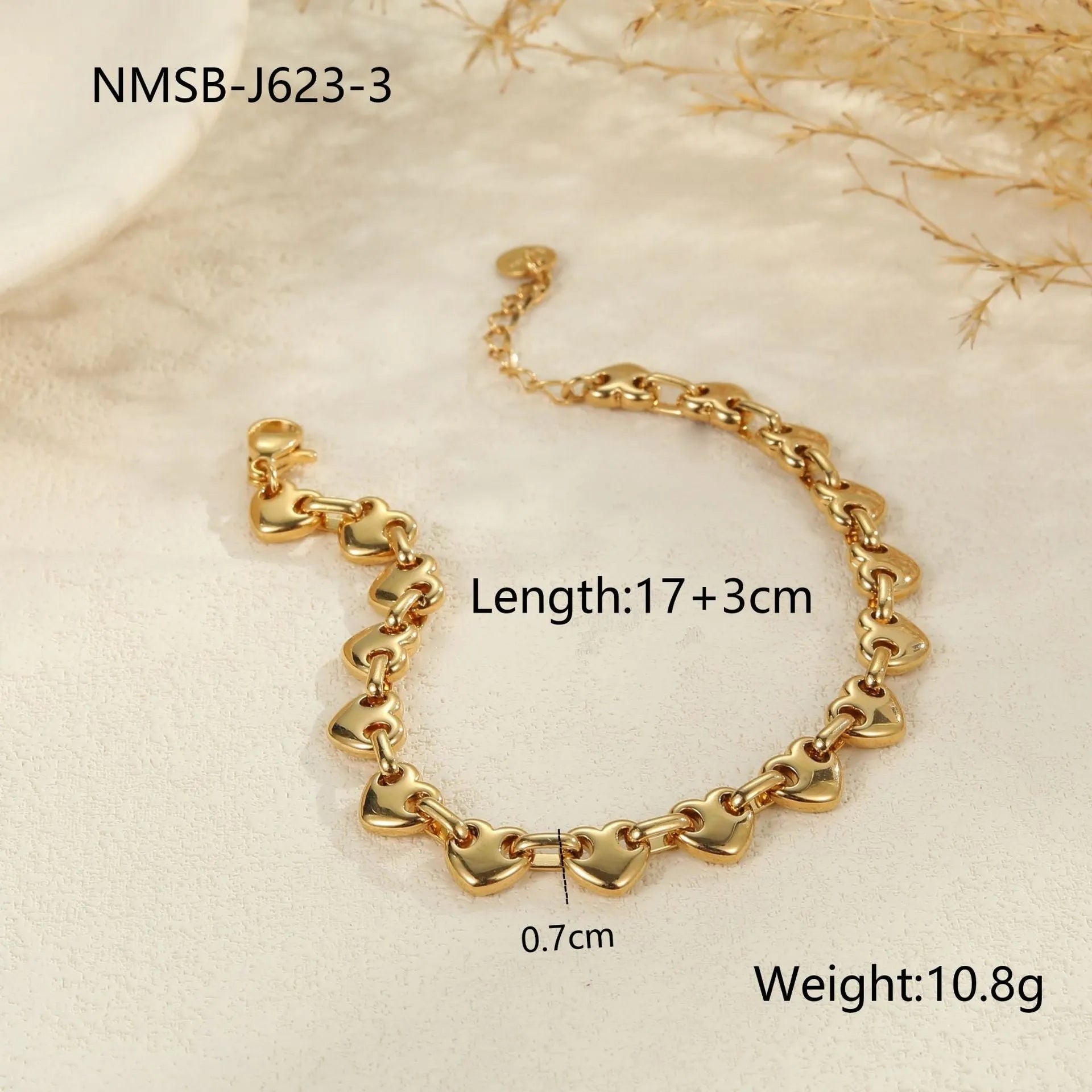 Hollowed-out stainless steel heart bracelet in gold finish on a wrist.