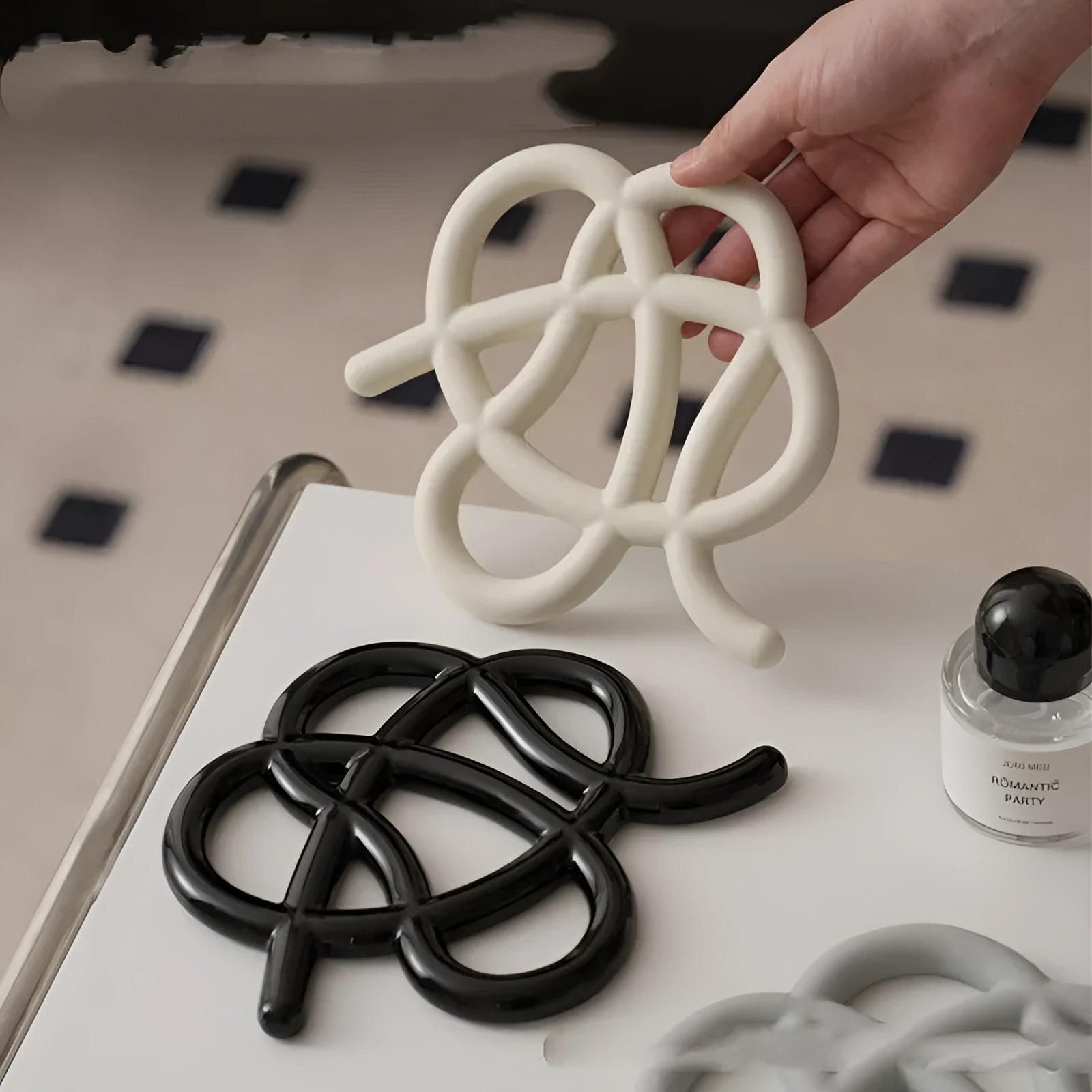 Ceramic heat proof mat in irregular shape showing bright black, coconut milk grey, and splash ink colour options