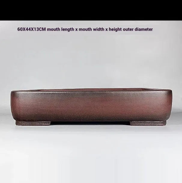 Handmade antique rectangular purple clay flower pot for plants on a tabletop.