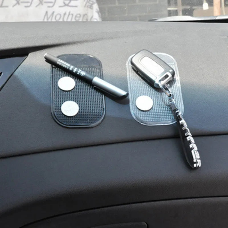 Black silicone car anti slip mat with spider-web texture, 13x7cm, on a car dashboard holding a smartphone
