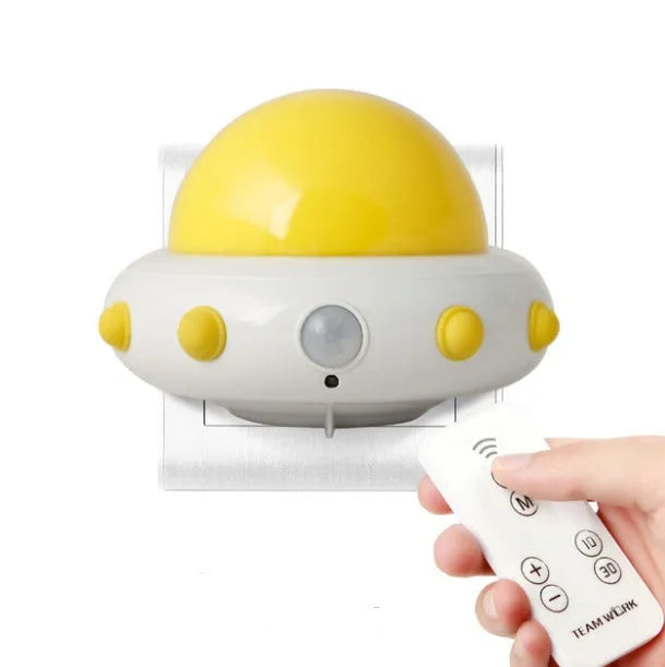 Remote control UFO-shaped bedside night light in blue, pink, or white colours.