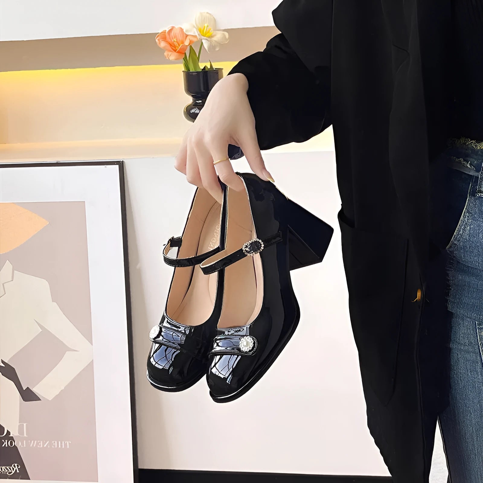 Women's black patent leather chunky heel shoes with round toe and buckle.