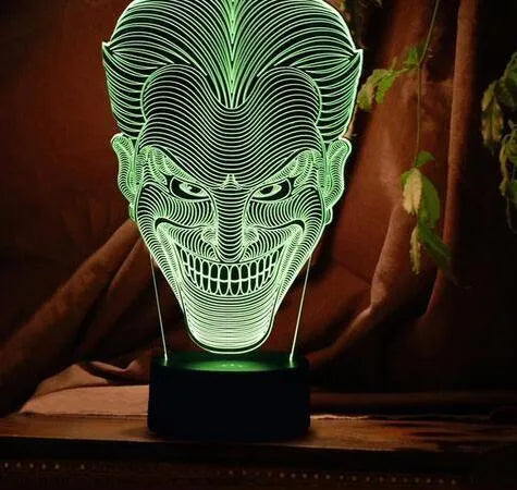 USB-powered 3D acrylic LED lamp showing seven colour options and remote control on a desk.