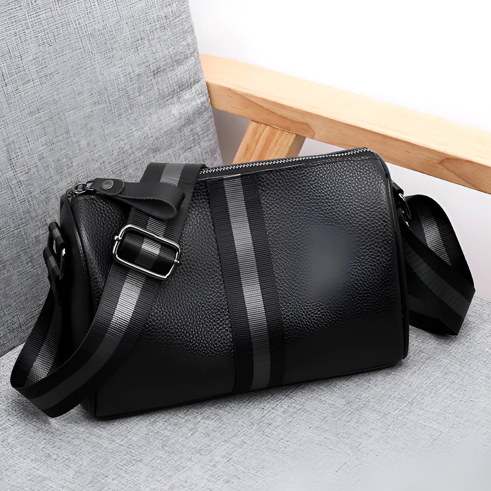 Black genuine leather crossbody bag with one shoulder strap showing interior polyester lining
