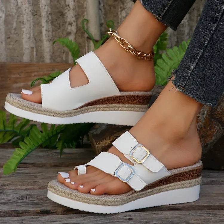 White wedge heel sandals with woven patent leather upper and peep toe design