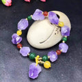 Natural shaped purple amethyst bead bracelet with a silver fu charm on an adjustable knotted cord.