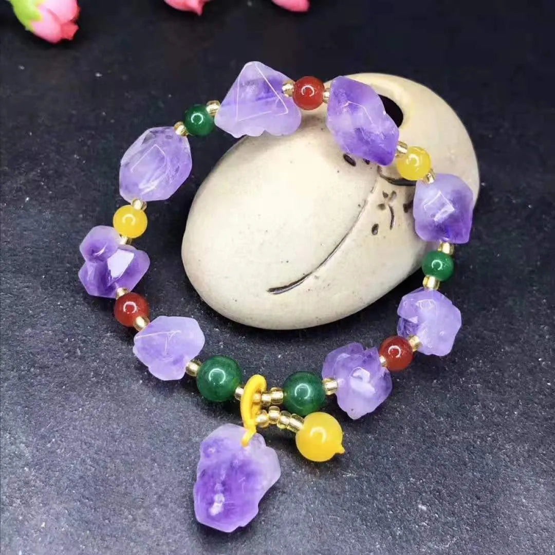 Natural shaped purple amethyst bead bracelet with a silver fu charm on an adjustable knotted cord.