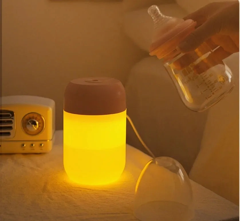 Small white cylindrical USB humidifier with charging cable on table