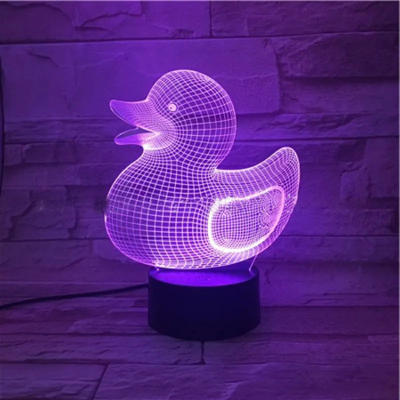 Little yellow duck 3D night light with remote control on a table, showing colourful LED illumination.
