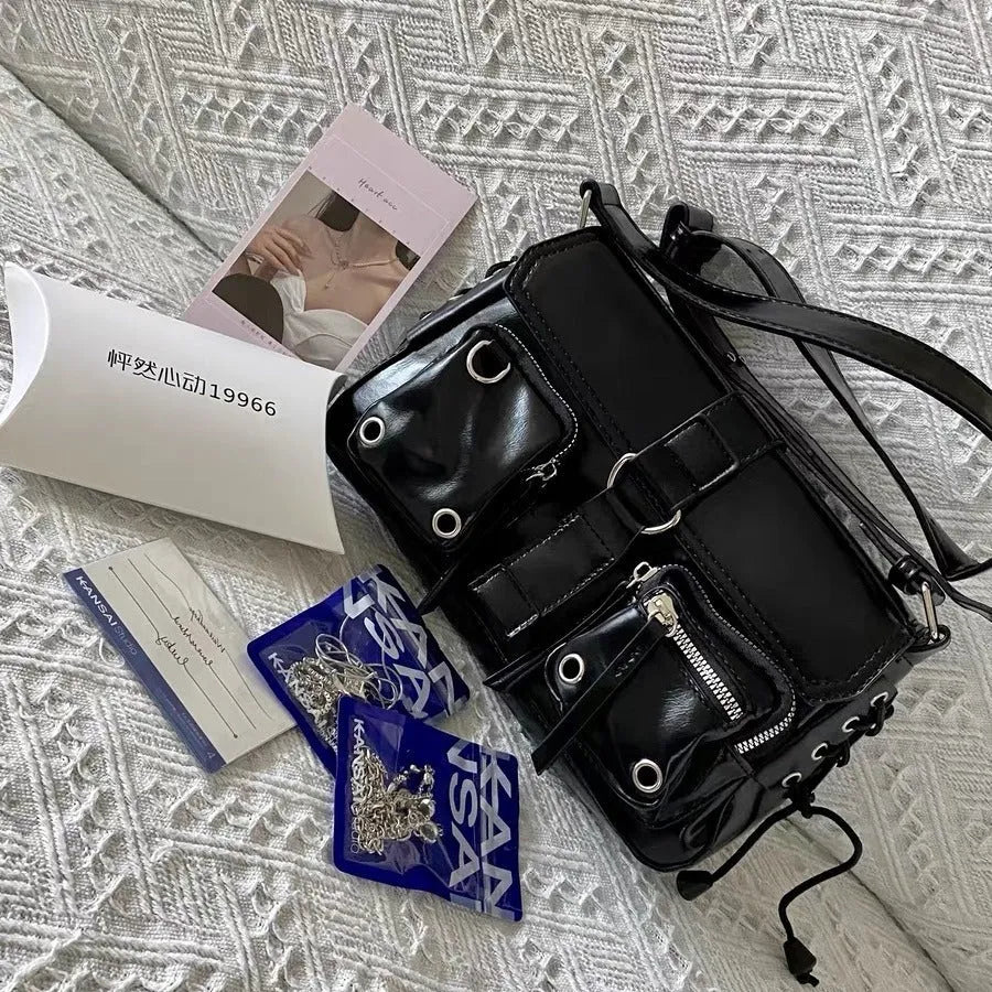 Black underarm baguette messenger bag with adjustable shoulder strap showing structured design