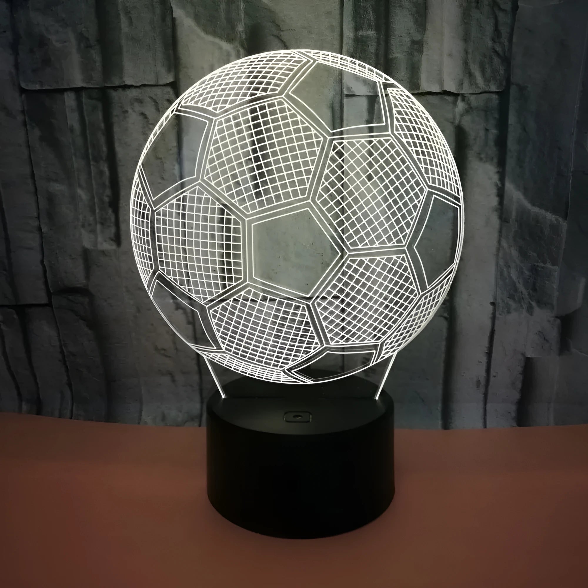 3D acrylic football night light on a square black base, showing multi-coloured LED illumination.