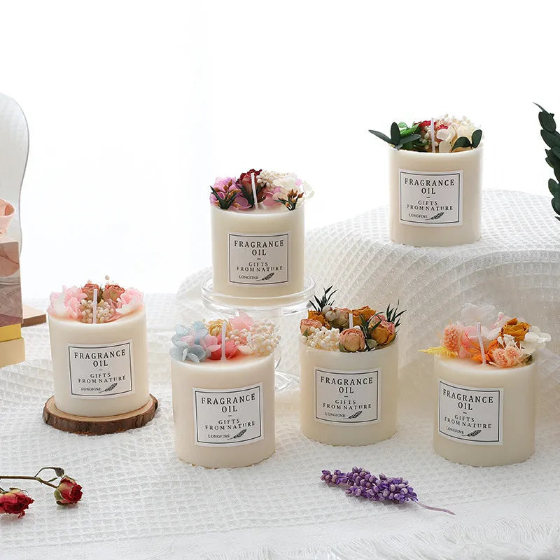 Decorative aromatherapy candle with dried flowers on top, shown in a choice of scents next to its wooden chip base and gift box.