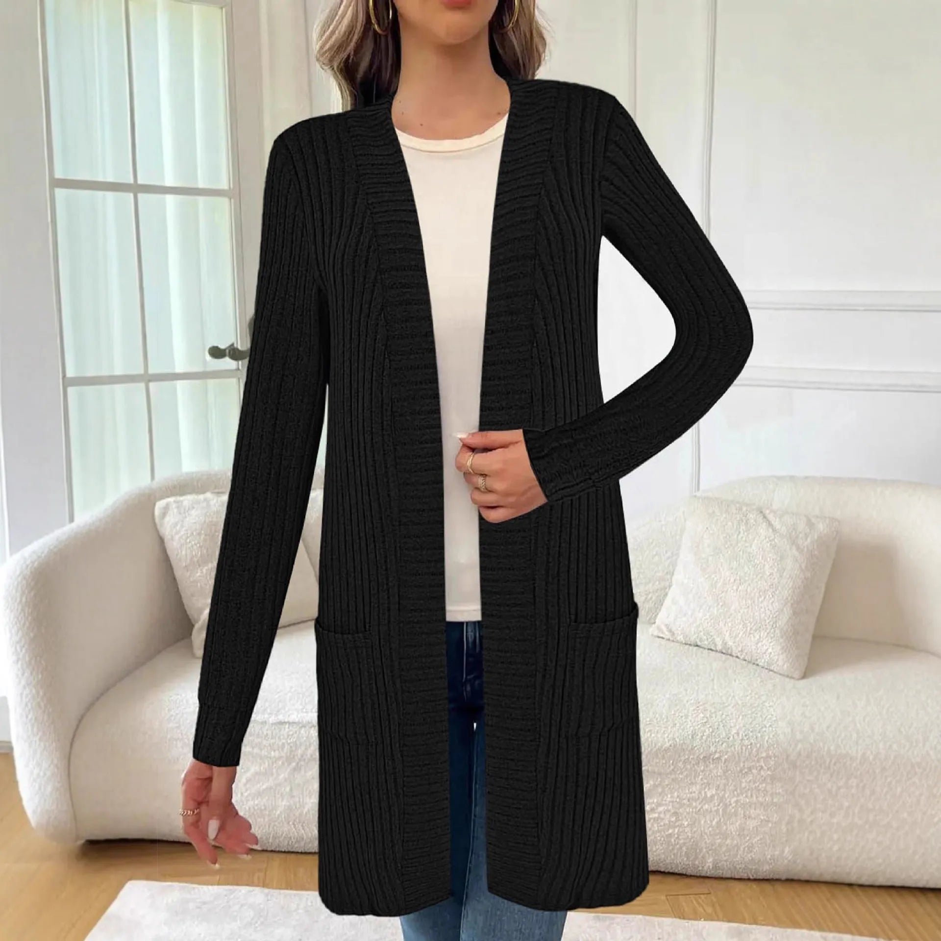 Black oversized knitted cardigan jacket with long sleeves and loose pockets.