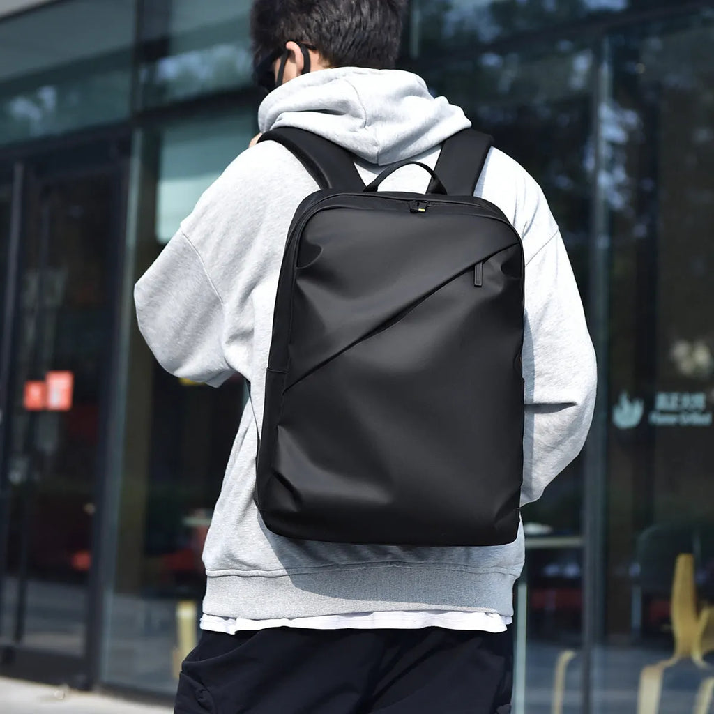 Waterproof PU leather men's backpack in black, blue and grey colour options showing large capacity design