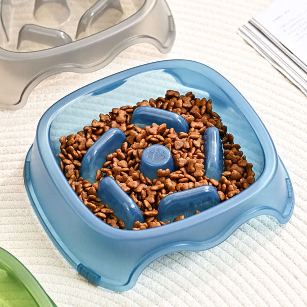 Blue plastic slow-feeder dog bowl on a wooden floor.
