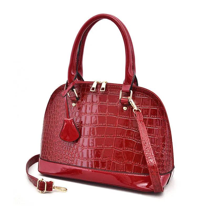 Large shiny black PU leather crossbody shoulder bag with shell shape on a white background