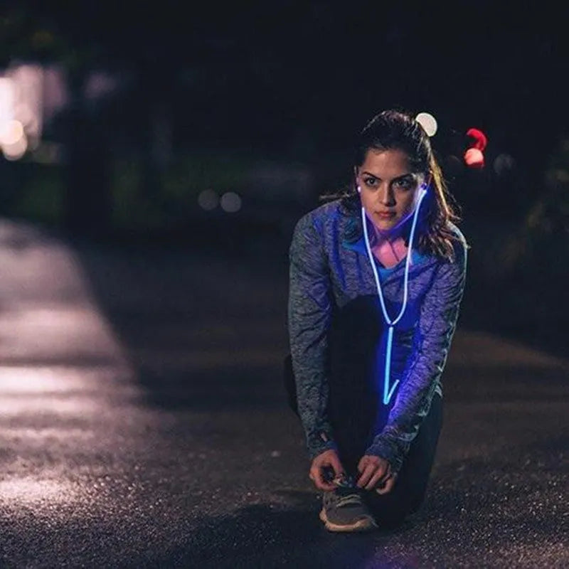 Blue Magic Light LED earphones with aluminium alloy shells and glowing cable connected to a phone.