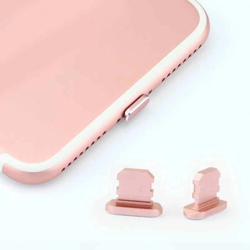 Aluminium alloy iPhone charging port dust plug in rose gold colour next to an iPhone.