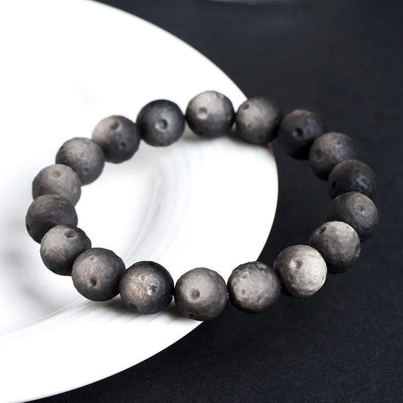 Obsidian crater ball bracelet in silver stone meteorite colour with textured round beads.