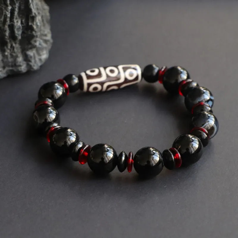 Hand-woven black agate Dzi bead bracelet with 11mm geometric beads on a wrist