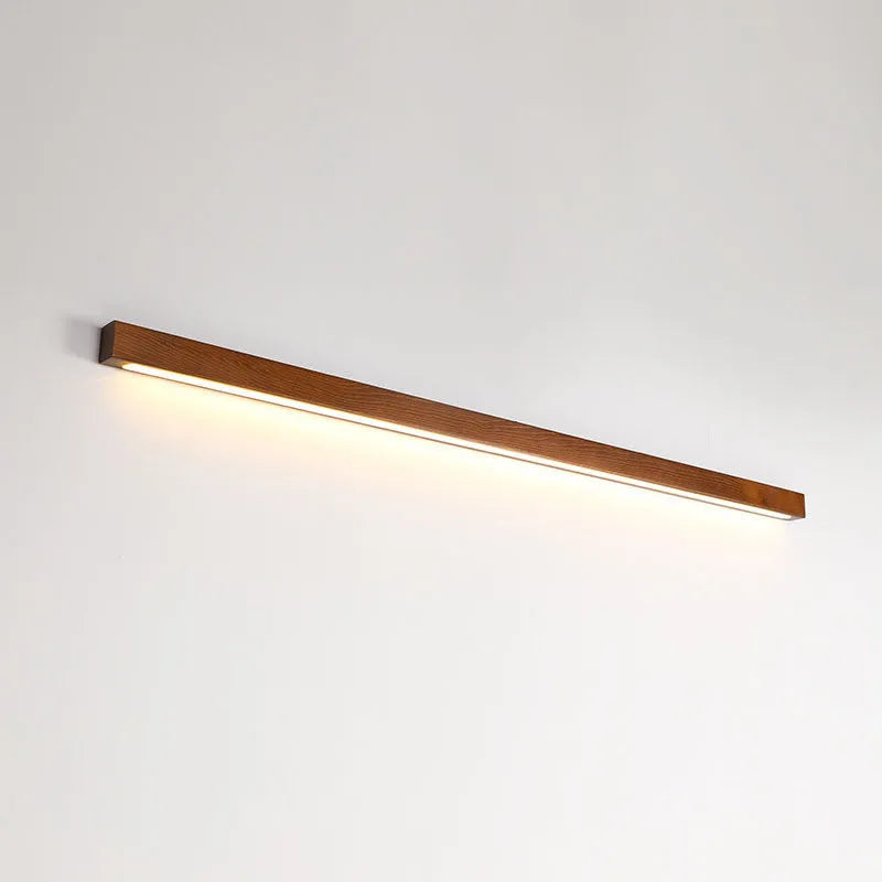 Modern walnut-colour wooden log strip LED wall lamp mounted on a wall.