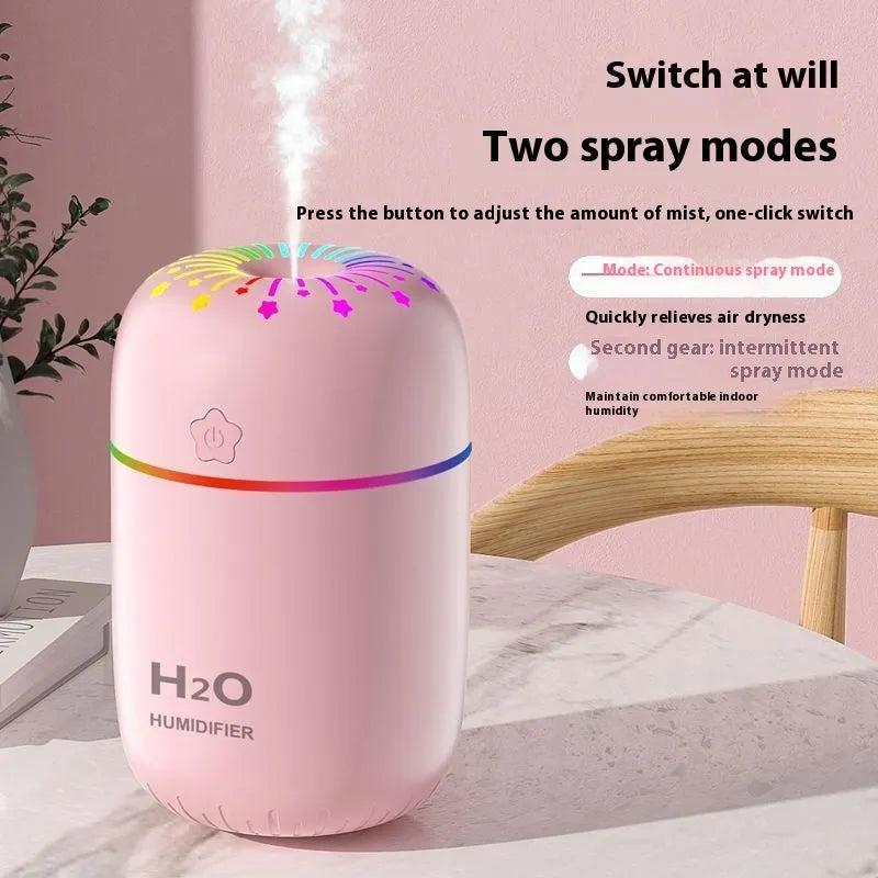 Small white cube-shaped USB humidifier with water tank on a wooden desk.