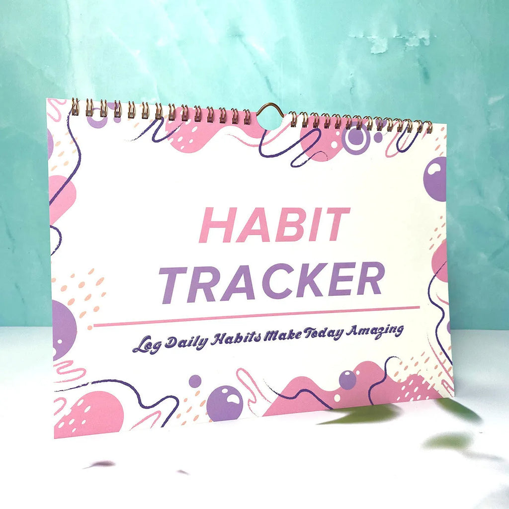 Habit tracking journal open showing internal pages with 21x28cm dimensions and coloured cover