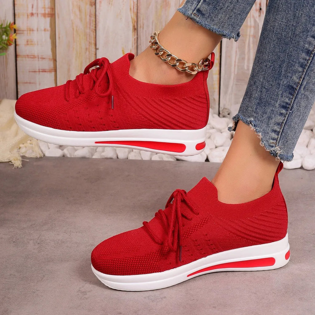 Women's red fly-knit low-top sneakers with round toe and front lace-up closure on artificial PU upper