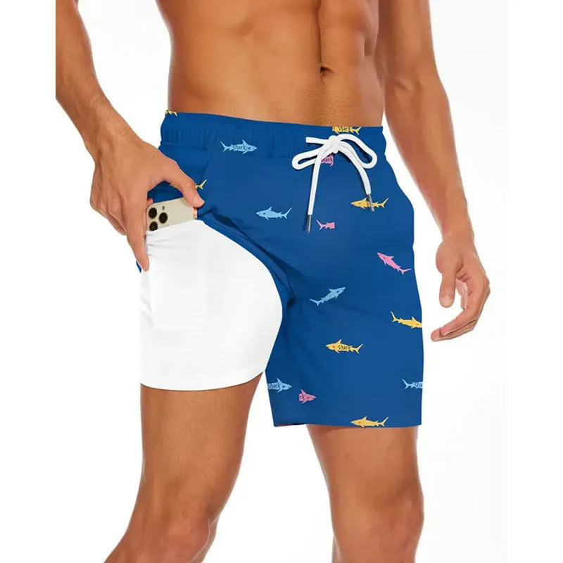 Man wearing loose grey polyester beach shorts on sand, showing casual fit.