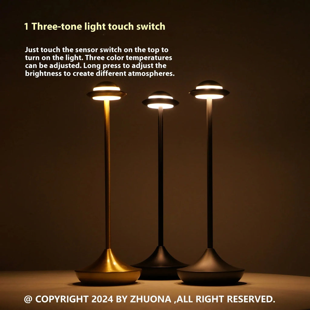 Modern black UFO-shaped rechargeable table lamp with touch-sensitive dimming controls on a wooden desk.