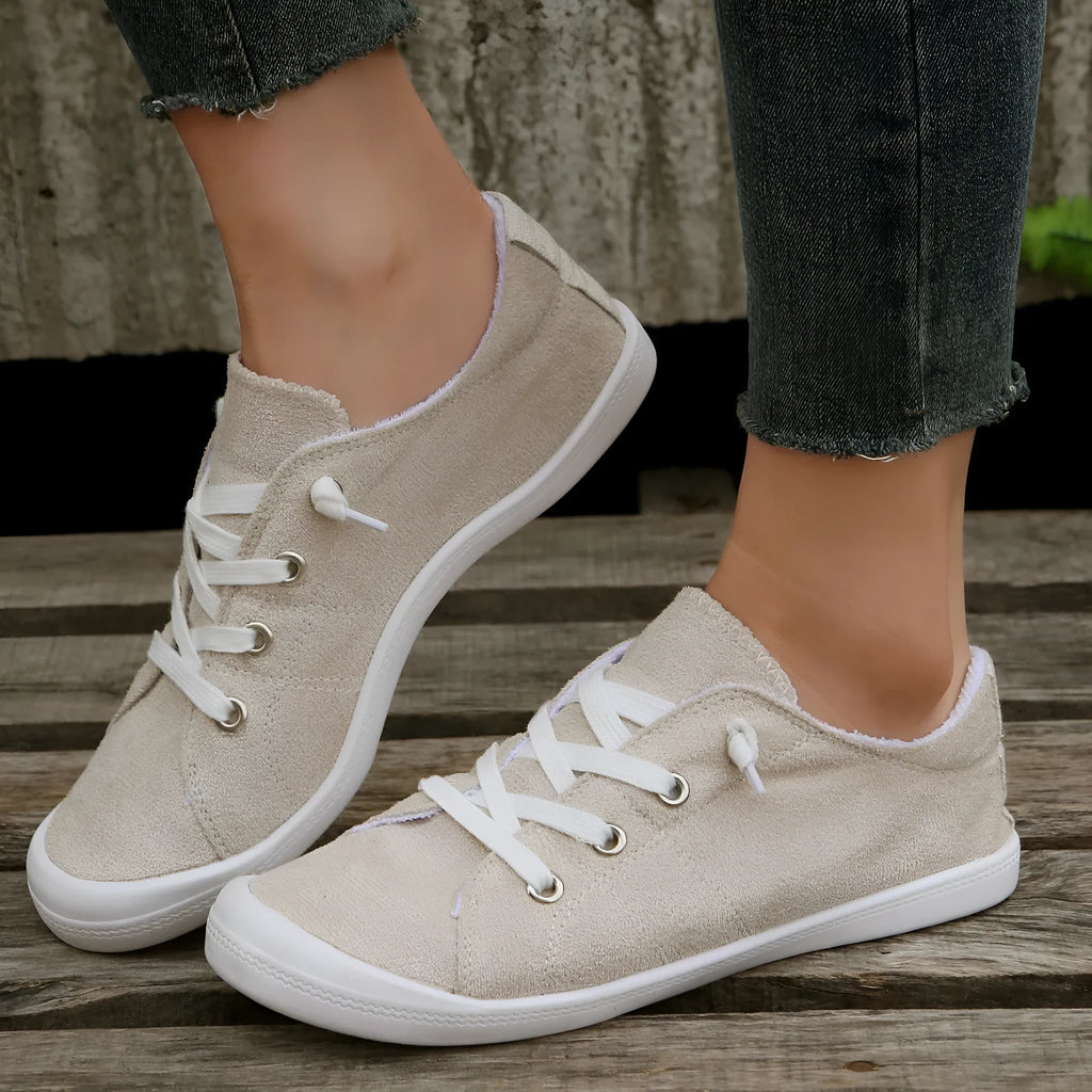 Women's creamy white casual low-top sneaker with soft fabric upper and rubber sole.