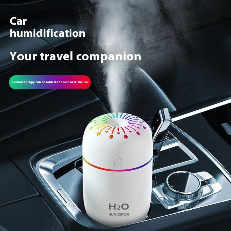 Small white cube-shaped USB humidifier with water tank on a wooden desk.