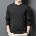 A man wearing a round neck, long sleeve wool pullover sweater in a caramel colour.