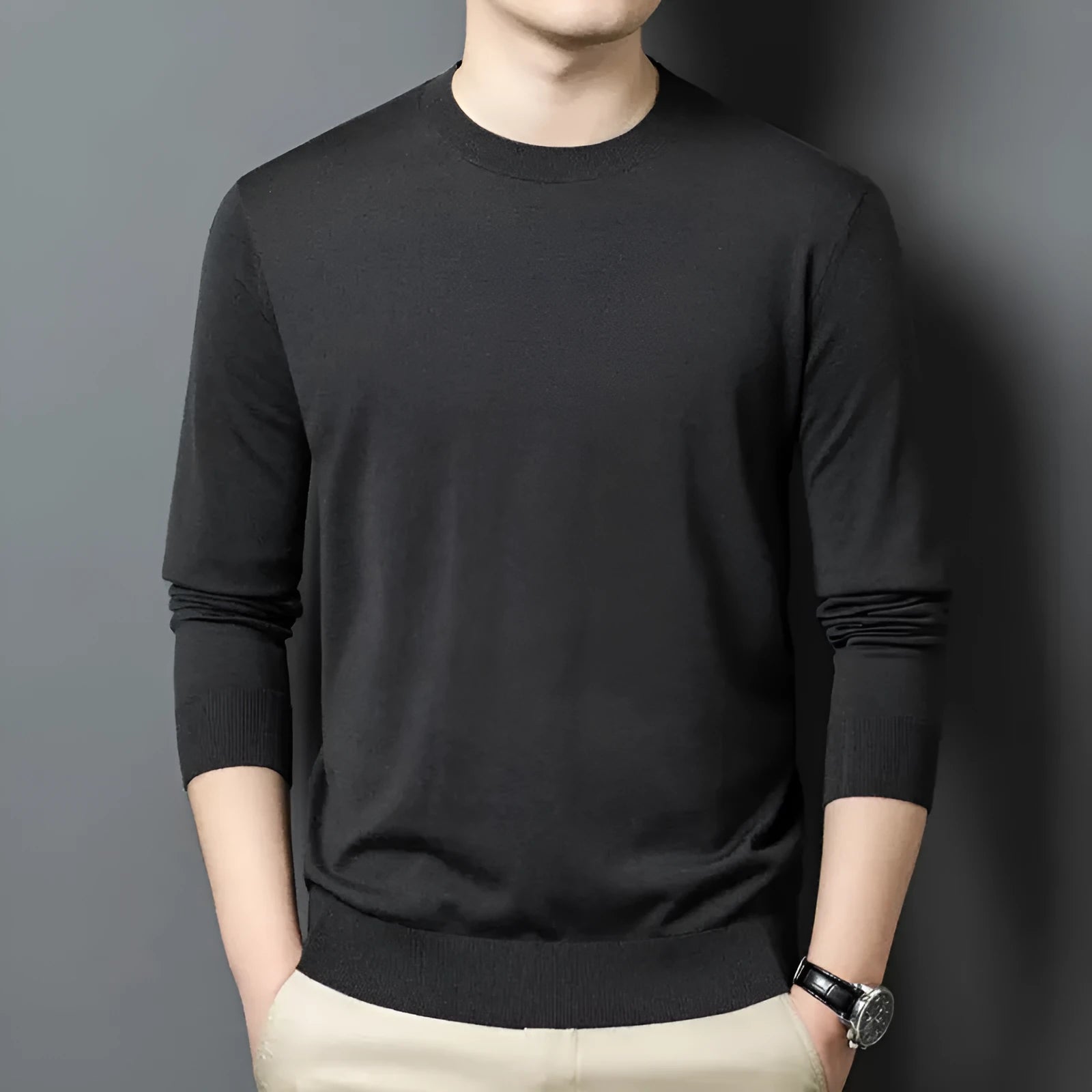 A man wearing a round neck, long sleeve wool pullover sweater in a caramel colour.