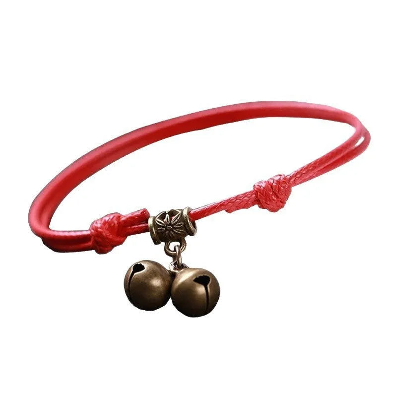 Nylon rope dog collar with brass bell on a black background, showing adjustable strap and buckle.