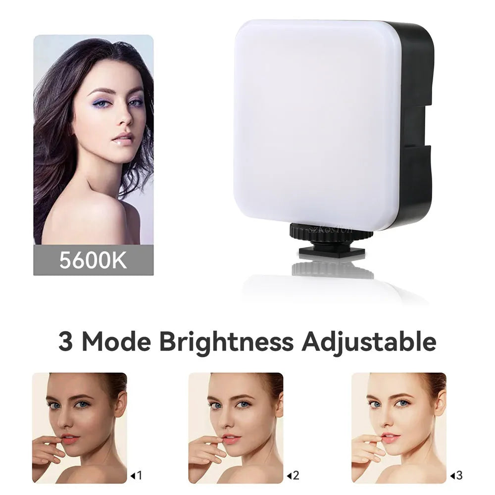 Square-shaped mini LED camera flash with hot shoe mount on a small tripod stand.